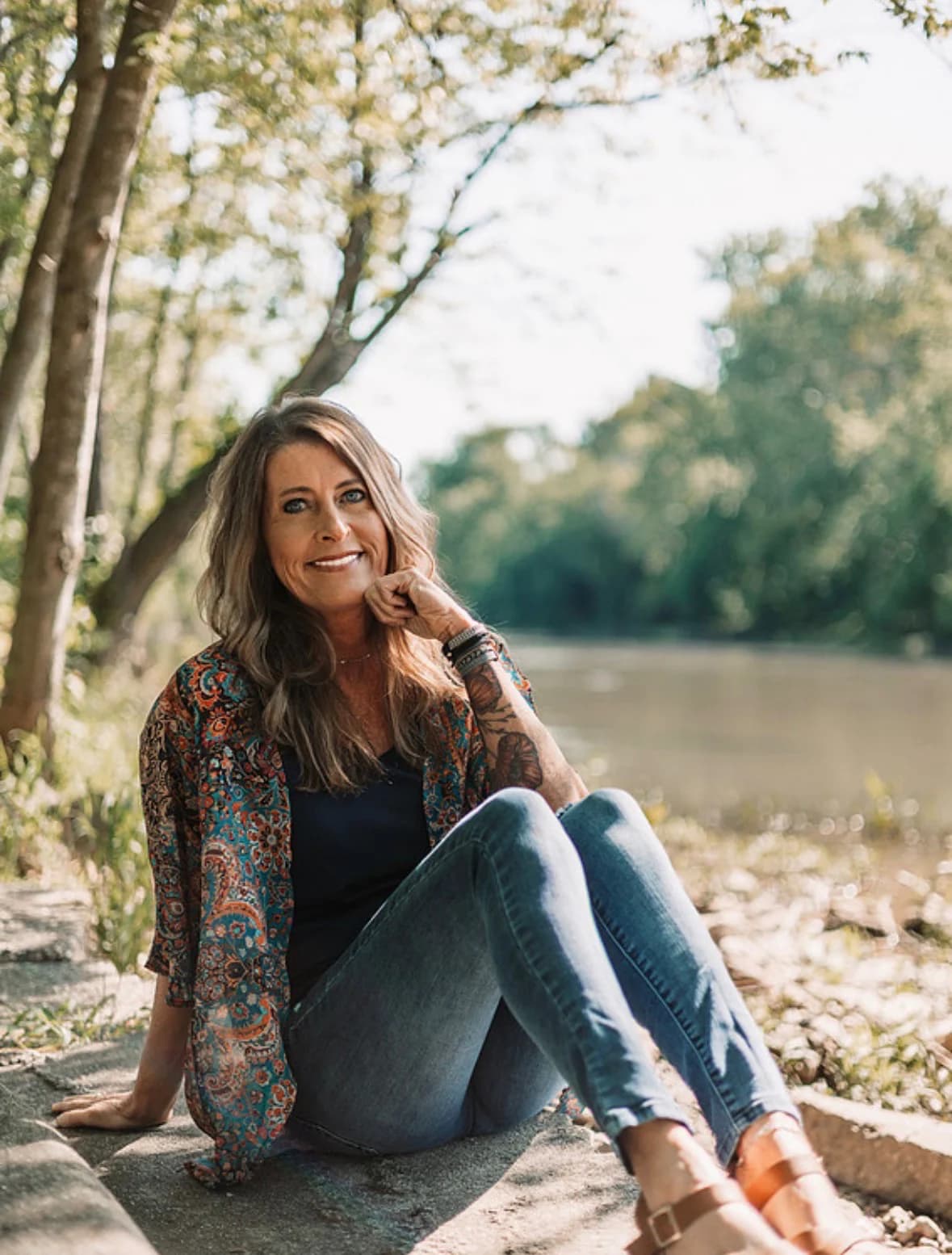 Kandace Cain seated near the river in a reflective setting